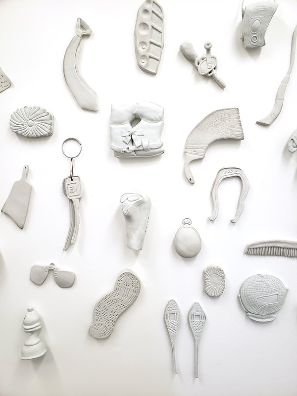 distorted porcelain objects on a white wall
