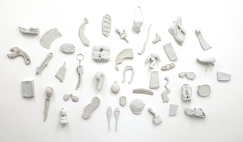 distorted porcelain objects on a white wal
